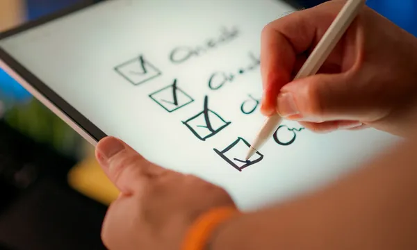 A hand marks off items on a checklist.